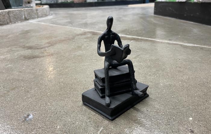 salg af Mand med bog sort metal