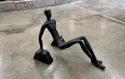 salg af Mand siddende på hænder sort metal