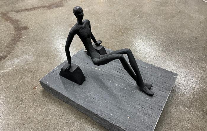 salg af Mand siddende på hænder sort metal